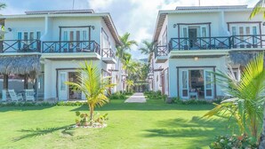 Un complexe hôtelier composé d’immeubles à deux étages, d’un chemin principal et d’un aménagement paysager de style tropical.