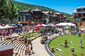 A bustling outdoor area with a pool, surrounded by buildings with traditional architecture. - Guest Room, One King (Vail)