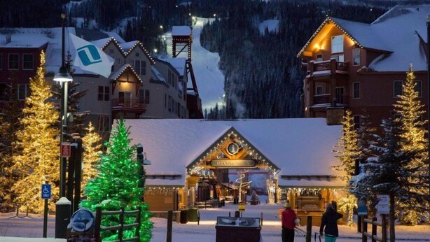 A snow-covered village with traditional wooden buildings, a Christmas tree, and a ski lift in the background. - 3 Bedroom Condo (Keystone)