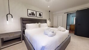 A modern bedroom with a large bed, bedside tables, and a wardrobe. - 2 Bedroom Condo (Vail)