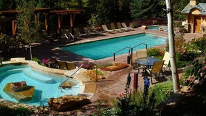 Ein Swimmingpool mit Whirlpool, Liegestühlen und einer Pergola.