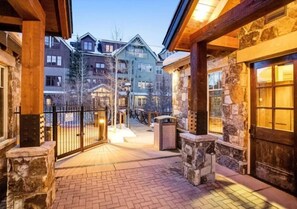 A stone building with a wooden porch and a brick pathway. - 2 Bedroom - Water House (Breckenridge)