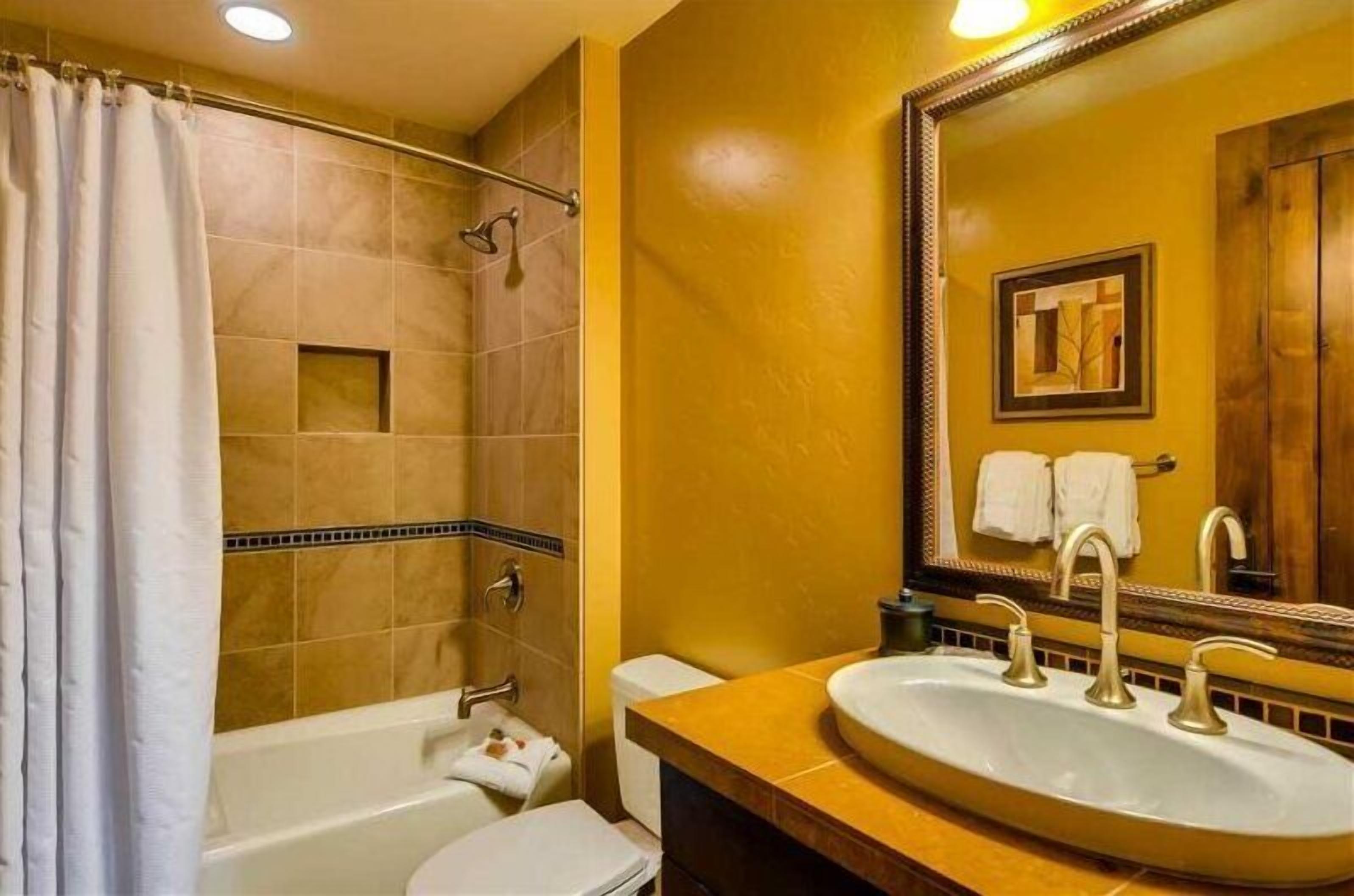 A bathroom with a bathtub, toilet, and sink.
