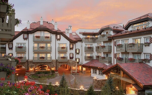 A multi-story hotel with balconies, a central courtyard, and outdoor lighting.