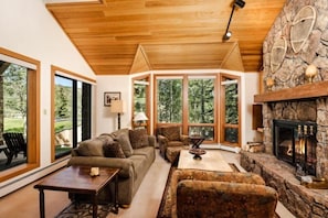 A cozy living room with a stone fireplace, large windows, and a wooden ceiling. - 2 Bedroom Residence (Snowmass Village)