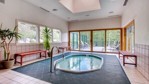 A pool area with a hot tub, benches, and potted plants. - 3 Bedroom Condo (Keystone)