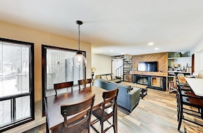 A modern living space with a dining area, sofa, and fireplace. - 3 Bedroom Condo (Keystone)