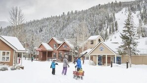 A snowy village with wooden buildings and a ski slope in the background. - 3 Bedroom Condo (Keystone)