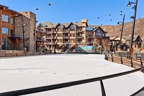 A ski resort with multi-story buildings, a ski lift, and a snow-covered ground. - One Bedroom Condo (Snowmass Village)