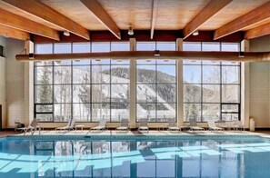 A large indoor swimming pool with clear views of a snowy mountain landscape through large windows. - 2 Bedroom Condo (Keystone)