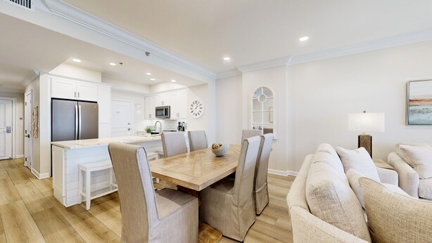 A modern kitchen with white cabinets, a stainless steel refrigerator, and a microwave. - Tides 0405 (Miramar Beach)