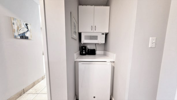 A compact kitchenette with a microwave, coffee maker, and a small refrigerator. - Summit 0407a (Miramar Beach)