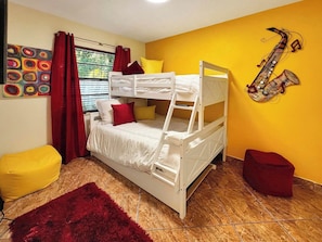 A bunk bed room with a red rug, a saxophone decoration, and a window with curtains. - Welcome To Dreamland Over 1 acre of private living (Apopka)