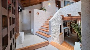 A modern interior with a wooden staircase, white walls, and a ceiling with exposed beams. - CASA EL MIRADOR-VALLE DE BRAVO (Valle de Bravo)