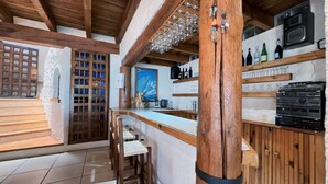 A rustic kitchen with wooden beams, a bar area, and a view of the sea. - CASA EL MIRADOR-VALLE DE BRAVO (Valle de Bravo)