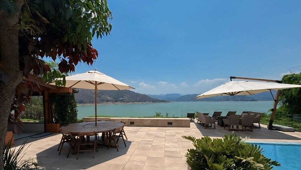 A patio area with a pool, outdoor seating, and a view of the sea. - CASA EL MIRADOR-VALLE DE BRAVO (Valle de Bravo)
