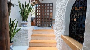A staircase leading to a door with a lattice design, flanked by white walls and wooden beams. - CASA EL MIRADOR-VALLE DE BRAVO (Valle de Bravo)