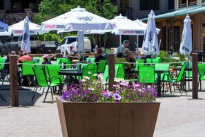 Espace extérieur aménagé avec des chaises vertes et des parasols blancs portant l’inscription « Espolon Tequila ».