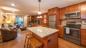 A modern kitchen with granite countertops, stainless steel appliances, and wooden cabinetry. - Ideal Location with 2 Queens + 2 Twins, Hot Tubs, Pool, & Clubhouse (Winter Park)