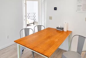 Un comedor con una mesa de madera y sillas de metal.
