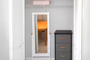 A room with a wardrobe, a mirror, and a bed. - Executive Suite Midtown (Wilmington)