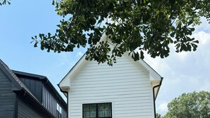 A two-story house with a covered porch, a small outdoor grill, and a fenced yard. - Built in 2024: 2100SF, 4-BR, 4-full-BA pet-friendly house in marvelous Apex (Apex)