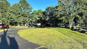 A residential street with a paved driveway, grassy lawn, and trees. - Beatiful Studio in Raynham MA, minutes to shopping, Massasoit State park, etc (Raynham)