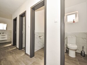 Et moderne badeværelse med toilet, bidet og et spejl.