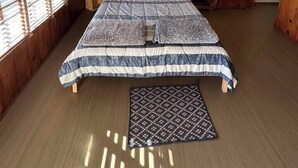 A wooden-paneled bedroom with a bed, bedside tables, and a window with blinds. - Room 5 • Desert Sanctuary  -  Downtown Joshua Tree (Joshua Tree)