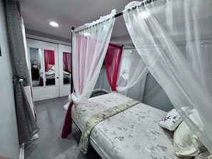 Une chambre à coucher avec un lit, une armoire et une fenêtre avec des rideaux.