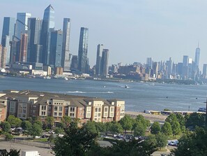 Une vue sur les toits d’une ville, avec des gratte-ciel modernes et une zone riveraine.