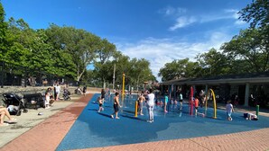 A playground with a blue rubberized surface, surrounded by trees and a covered seating area. - Nice two Bedroom apt at 25 Minutes to New York (North Bergen)