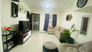 A living room with a TV, sofa, ottoman, and plants. - Whole house in San Fernando (San Fernando)