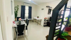A dining area with a table and chairs, a small white table, and a potted plant. - Whole house in San Fernando (San Fernando)