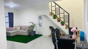 A modern living room with a sectional sofa, a glass dining table, and a staircase with potted plants. - Whole house in San Fernando (San Fernando)
