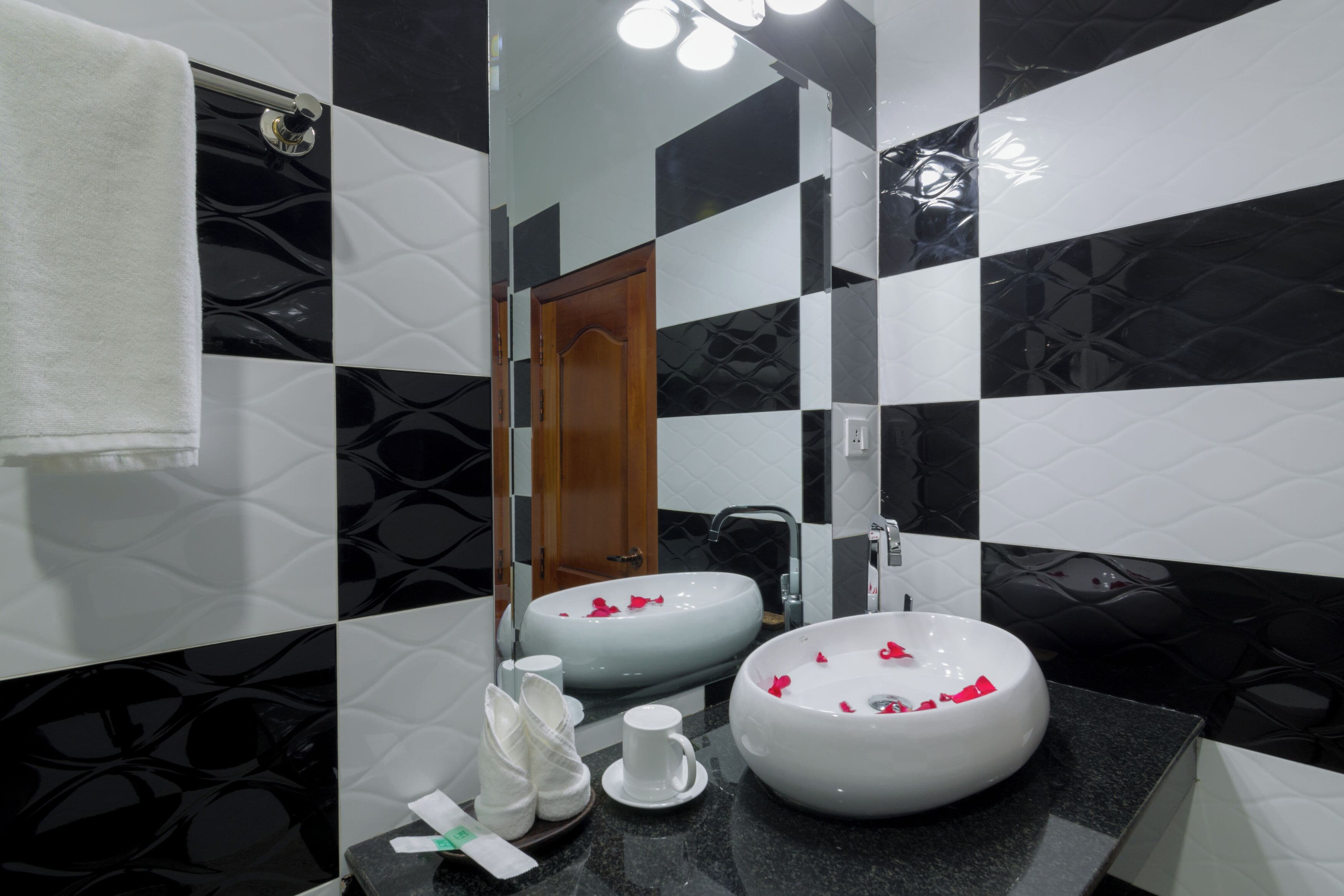 A bathroom with two sinks, a mirror, and a towel rack.