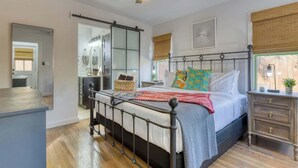 Un dormitori amb llit, taula de nit i ventilador de sostre.