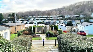 A residential area with mobile homes, a gated entrance, and a clear sky. - No 27 A. Field - Coghurst Hall Hastings (Hastings)