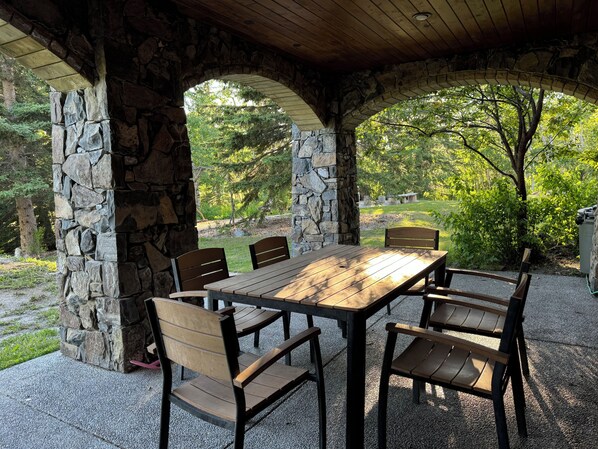 Relax in a serene outdoor setting surrounded by nature, with a patio table and chairs perfect for dining or socializing.