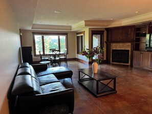 Relax in this stylish living room with a large sofa, dining area, and fireplace.