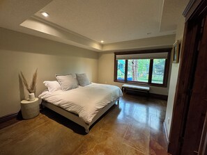 Relax in this serene bedroom with a large bed and a view of the playground outside.