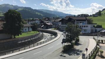 Una carretera serpentea por un pueblo con edificios y una montaña al fondo.