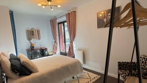 A bedroom with a bed, bedside table, chair, and a window with curtains. - Apartment t2 floor at the edge of the lot (Espalion)