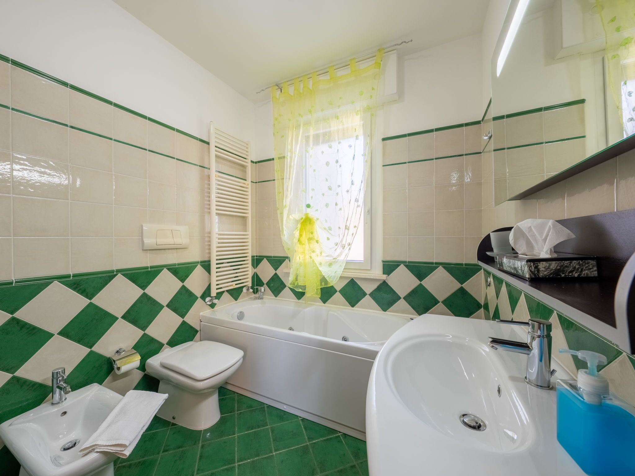 A bathroom with a bathtub, toilet, bidet, and sink.