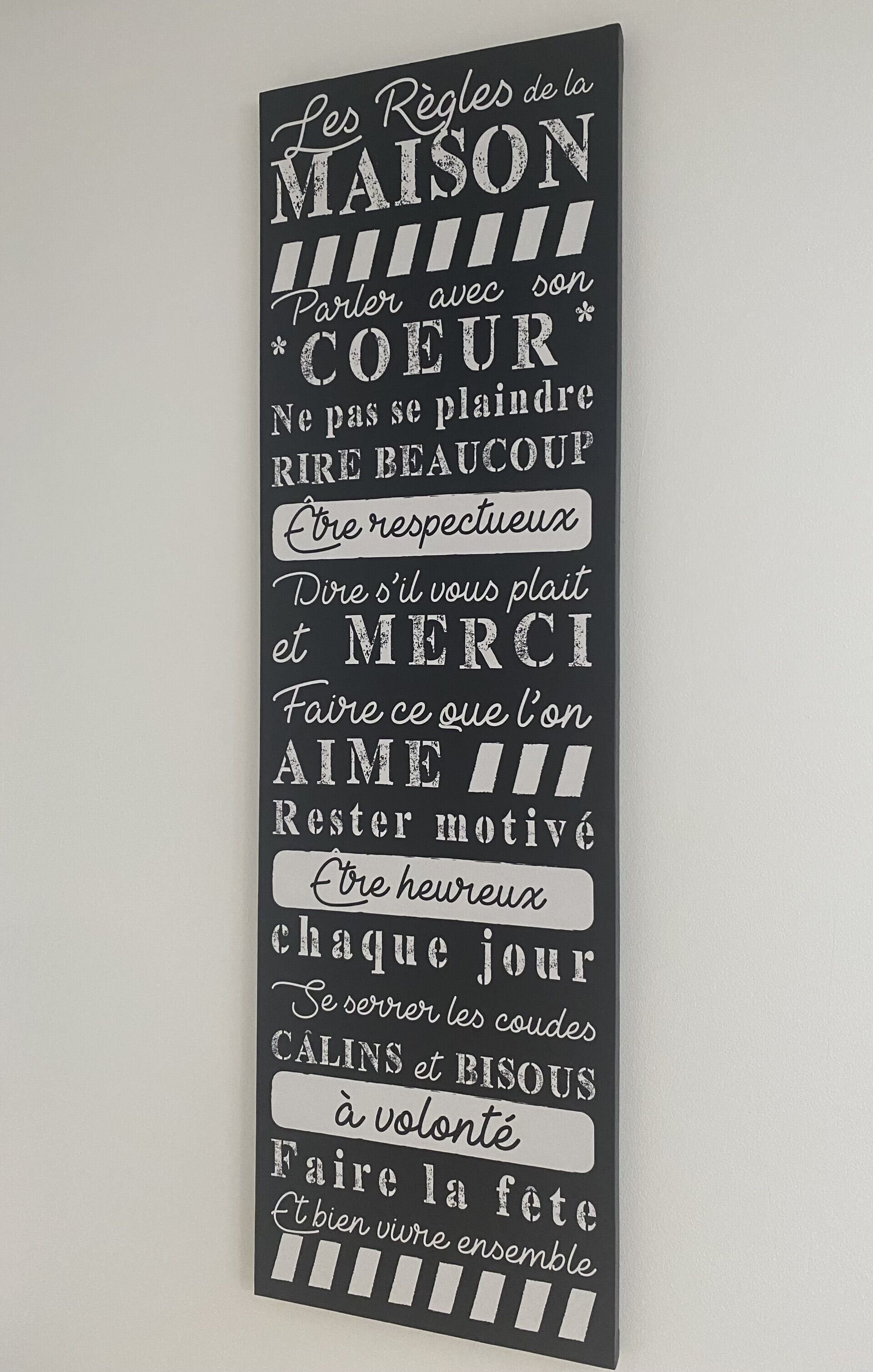 Un cartel vertical con texto en francés, probablemente una decoración de pared o letrero.