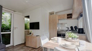 Une cuisine moderne avec des meubles en bois, un four encastré et une machine à café.