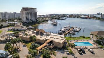 A hotel with a pool, marina, and marina docked boats.