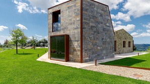A modern building with a stone facade, large windows, and a flat roof. - Private Villa with hot tub, private pool, A/C, WIFI, patio, pets allowed, close to San Gimignano (Volterra)