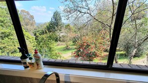 Une cuisine avec une fenêtre donnant sur un jardin.