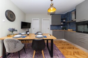 Cozy living space with a dining area and kitchenette, featuring a flat-screen TV and modern amenities.